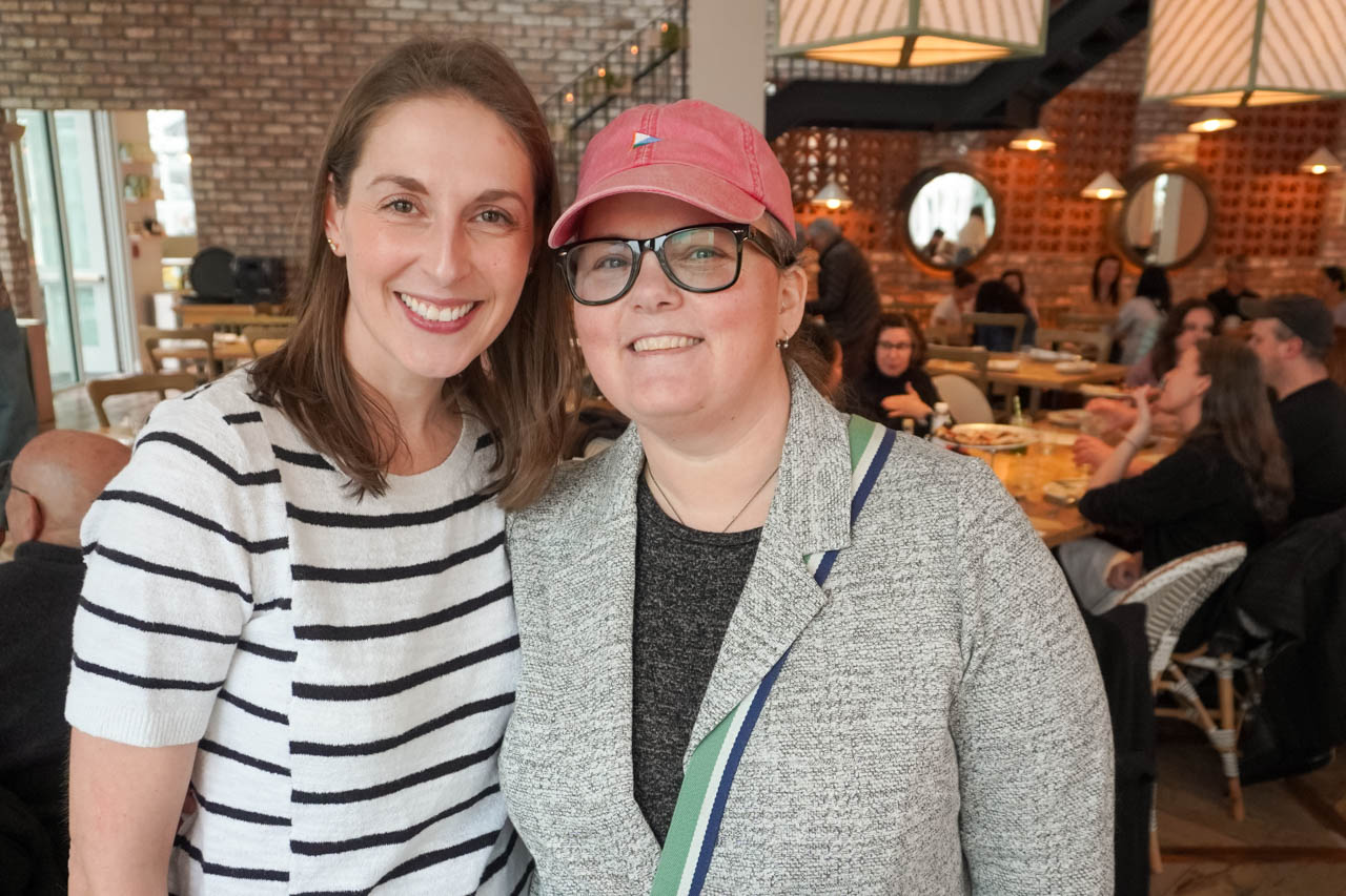 two women facing the camera inside a restaruant