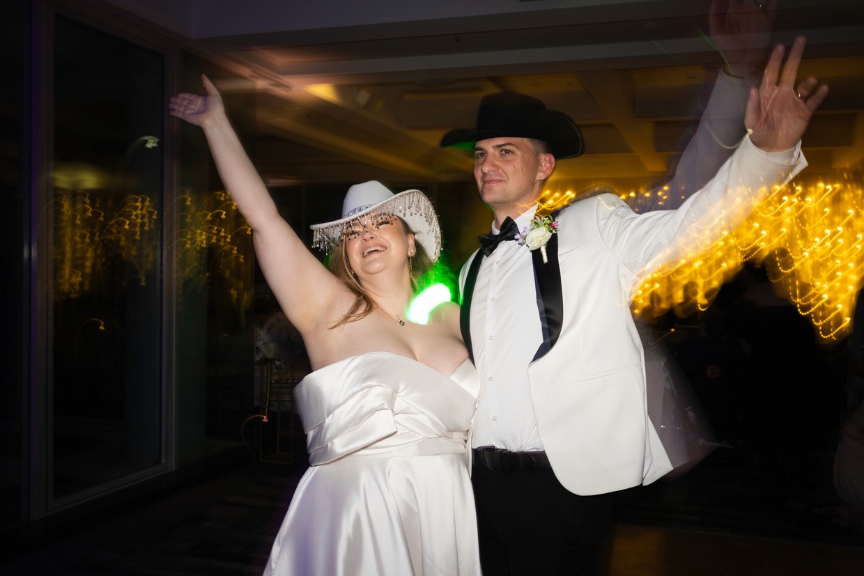 Bride and groom dancing with hands in their air
