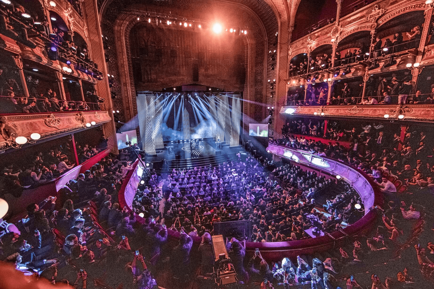 vue d'un évènement avec une scène et une foule de personne.
