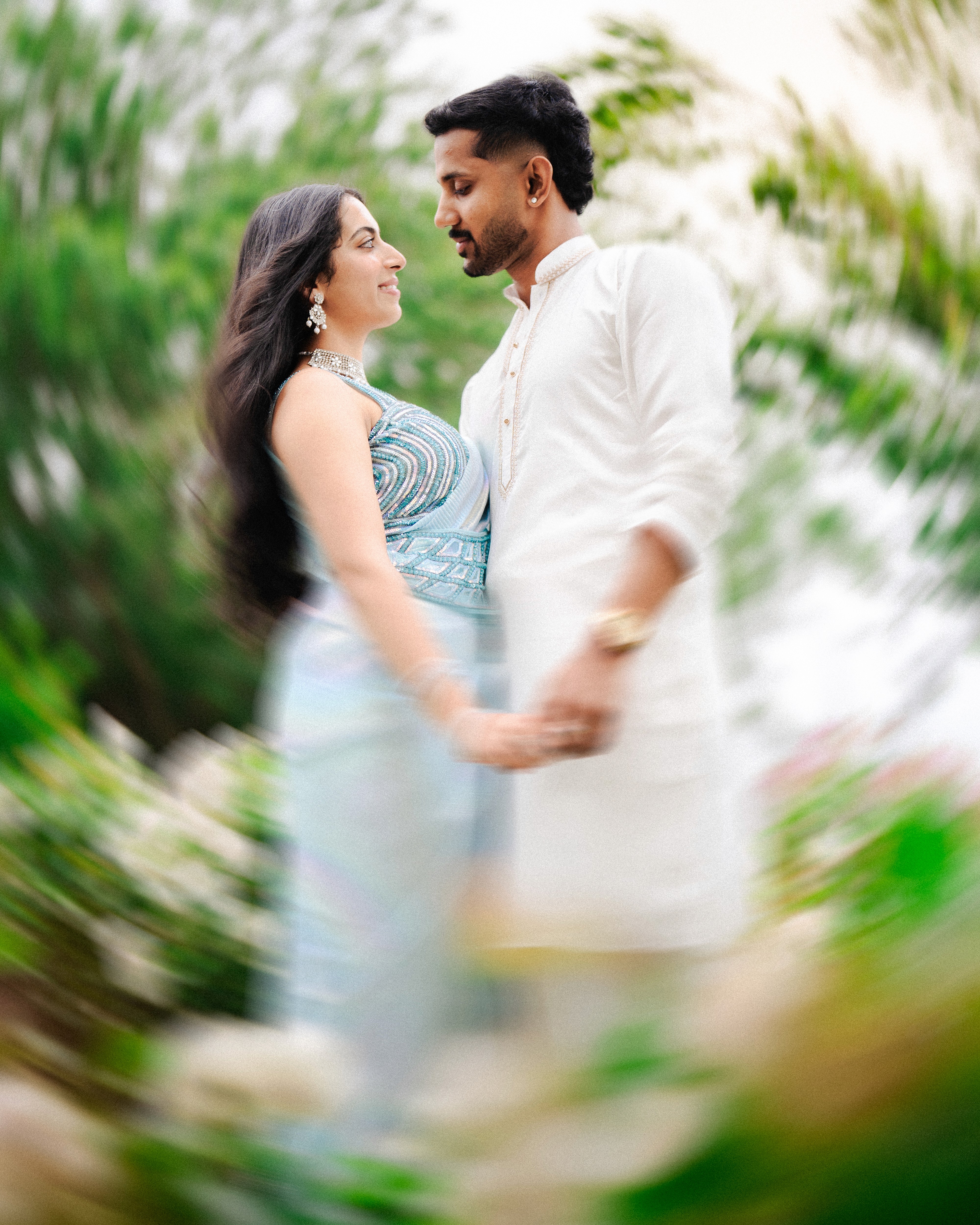 Palm trees and crowded beach with ocean in background.