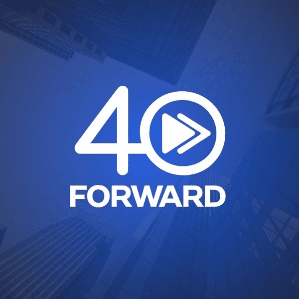 Two men reviewing documents together by a large window, with sunlight streaming in.