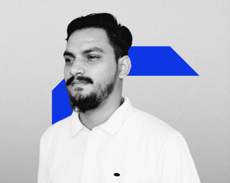 A woman with straight blonde hair wearing a light colored sweater looks away.