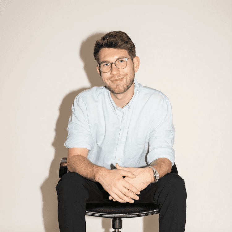 Portrait of a person in a pink sweater against a light background