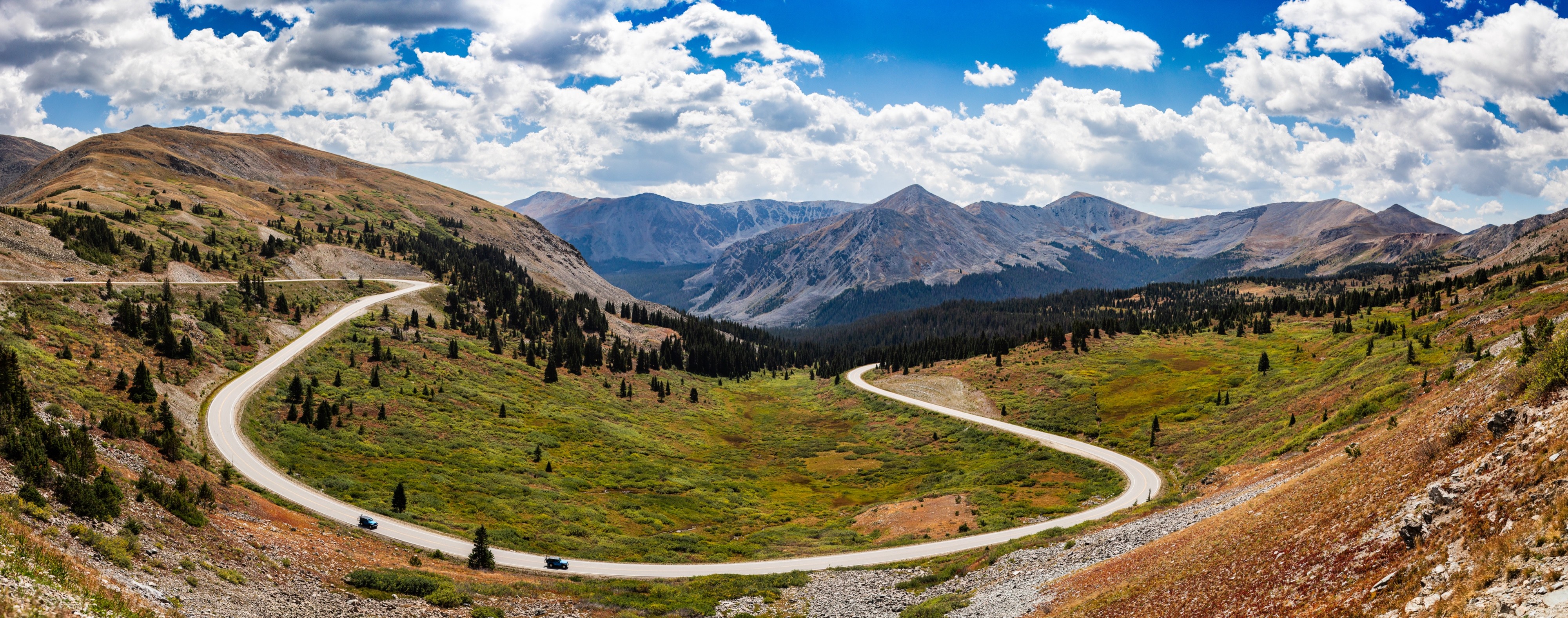 Panoramic landscape photograph of mountains, water, desert, or coast by Lucas Jensen