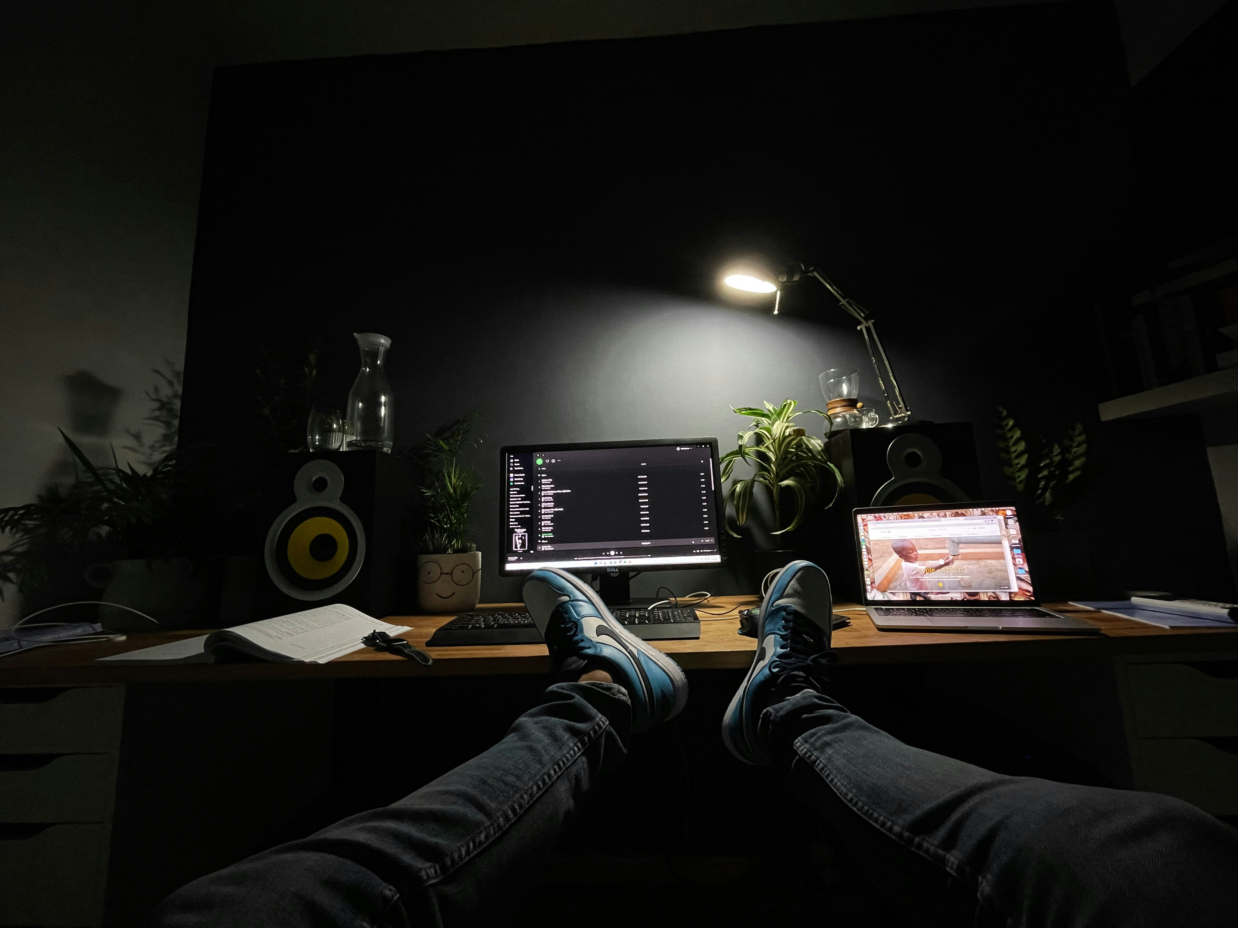 a person sits on a desk with a laptop
