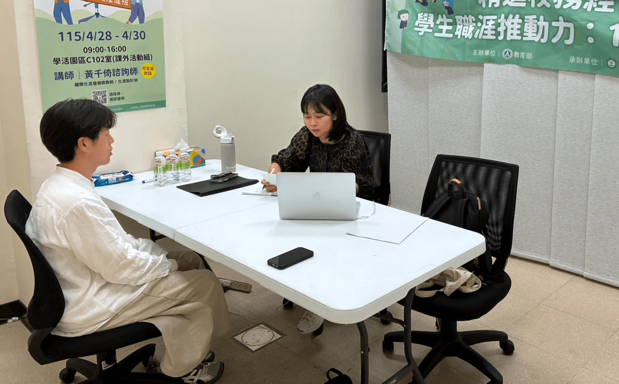 Two professional colleagues collaborating on a project with a laptop and papers