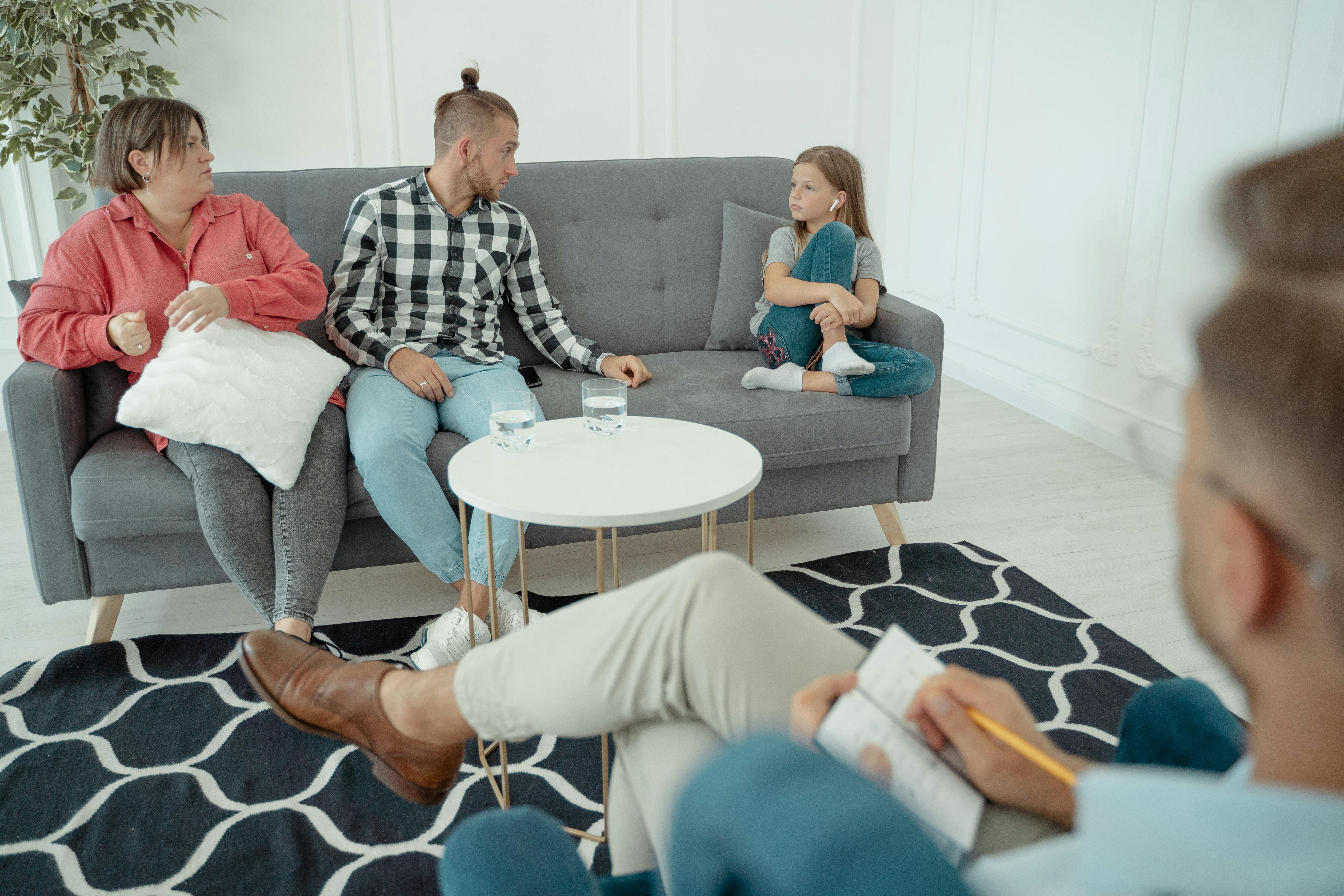Conversion Truth for Families - Mother, son, and toddler sitting on a gray couch at a counselor's office