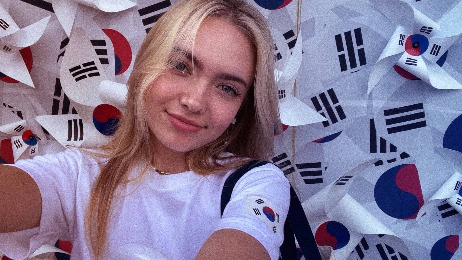 Cô gái Moldova selfie trước tường cờ Hàn Quốc — chia sẻ trải nghiệm kết bạn với người Hàn