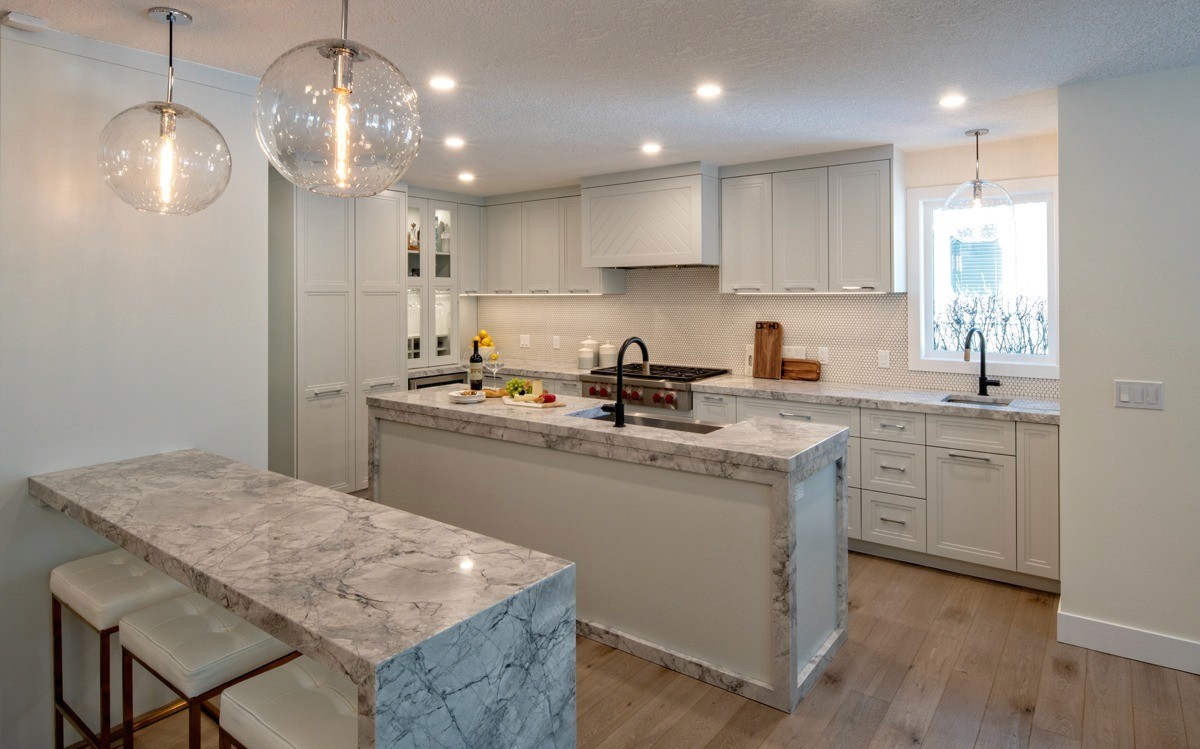 Image of KHD Homes kitchen design with marble countertops, white cabinetry, and modern layout design elements.