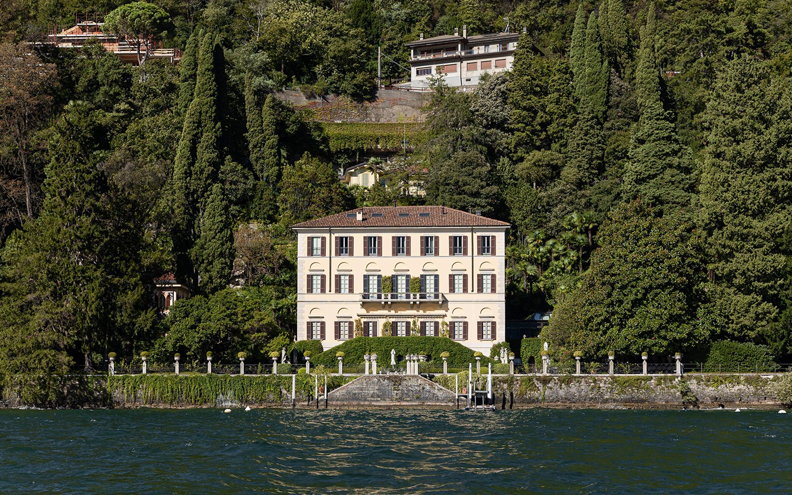 科莫湖畔的巴尔比亚内洛别墅，四周环绕着郁郁葱葱的绿色植物，俯瞰着湖水。