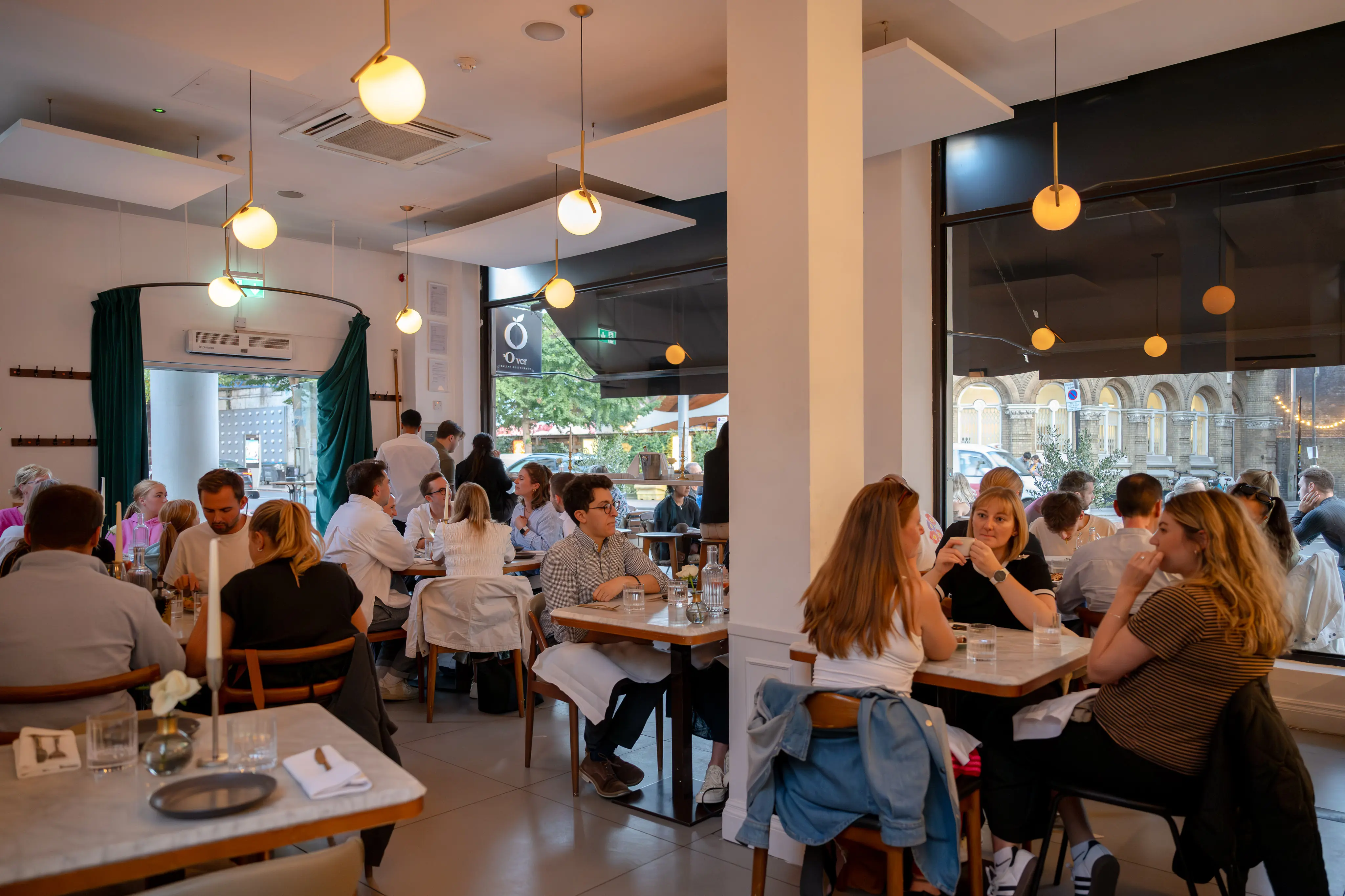 Diners inside 'O Ver Borough, an Italian restaurant near the Menier Chocolate Factory in Southwark, known for Neapolitan pizza and pre-show dining.