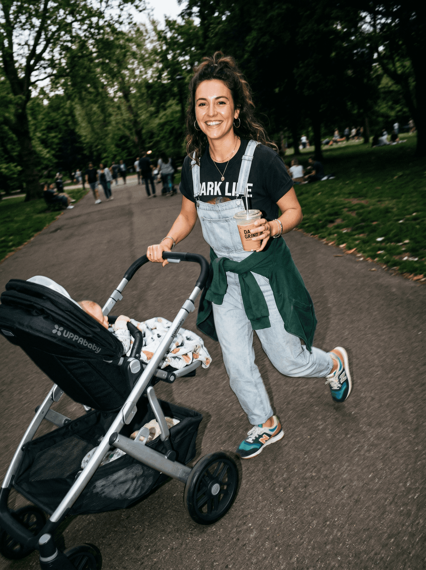 A mother walking in a park with a pram
