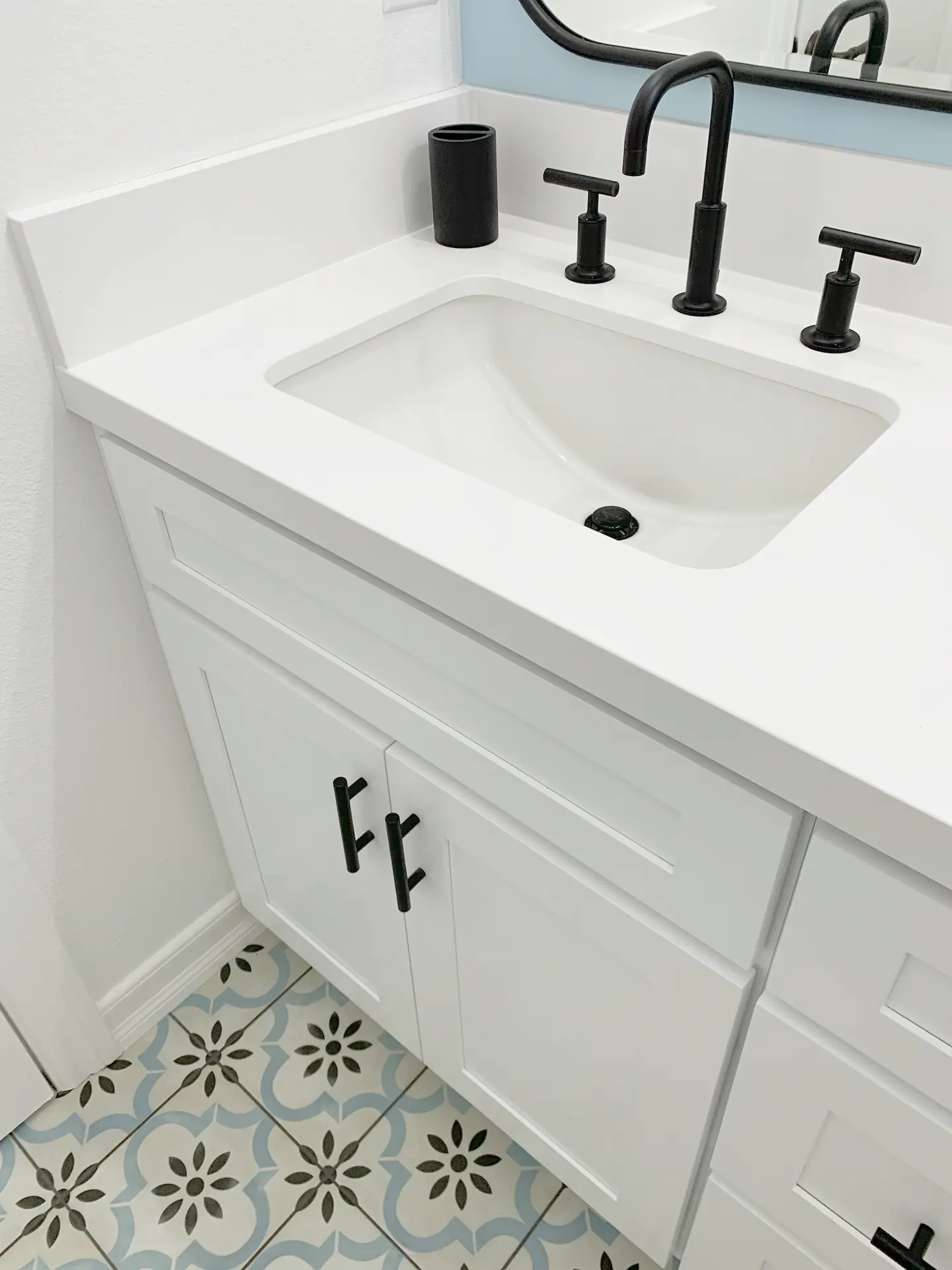 Closeup of the sink in the kids' bathroom, featuring black fixtures and a clean, contemporary design. Photo by Todd Huge.