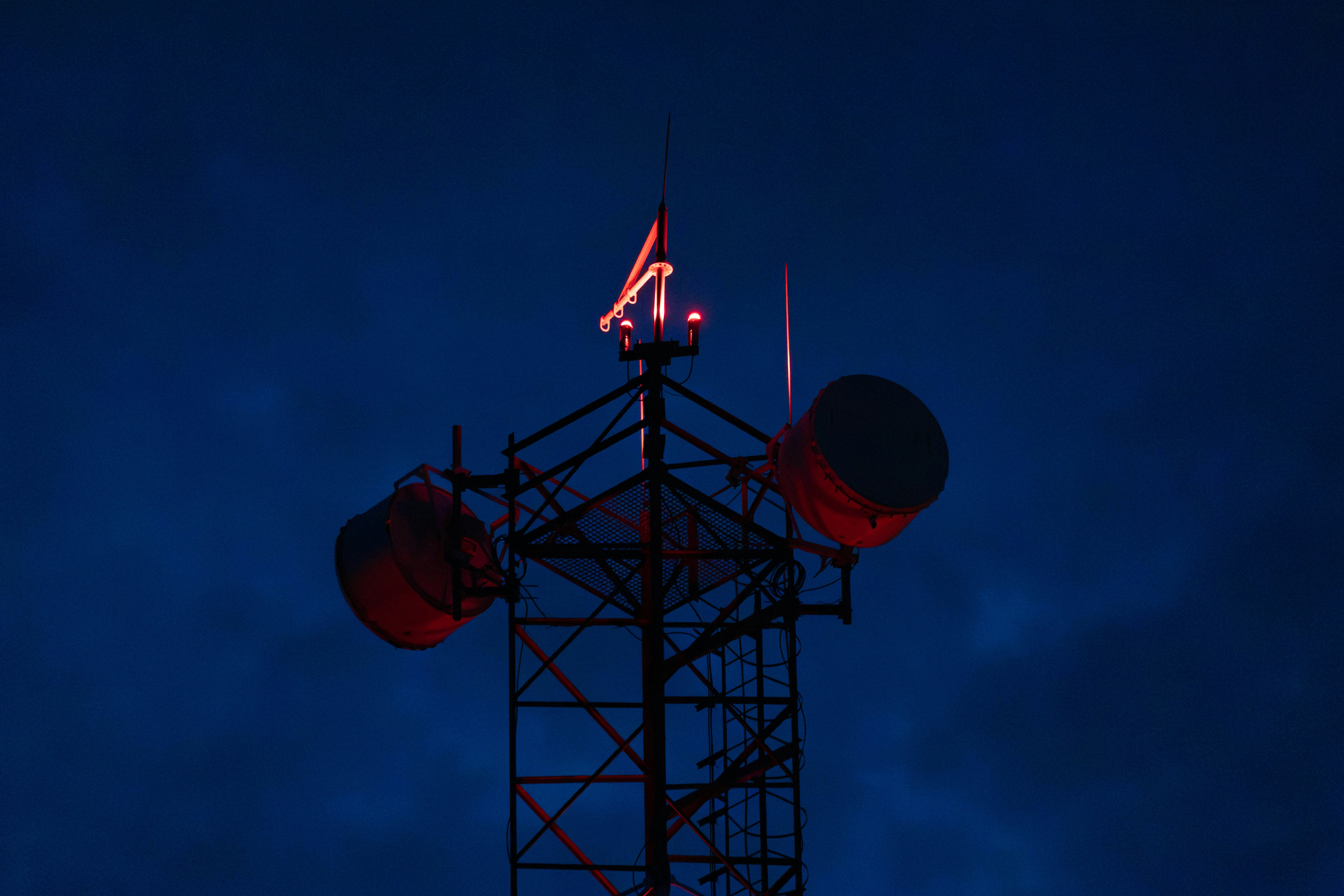 Cell tower with red lights against dark sky