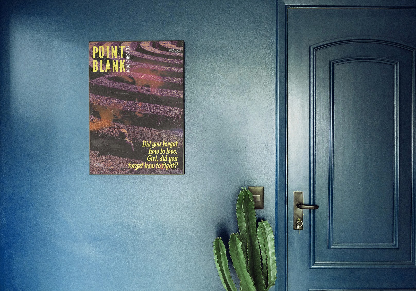 Textured purple editorial typography poster titled Point Blank mounted on a dark teal blue wall inside a modern interior studio space.