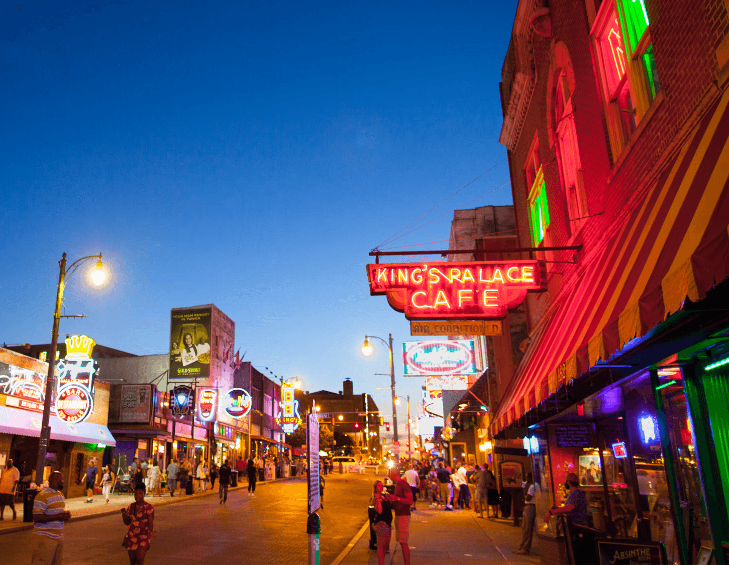 Portrait of a laughing person with curly hair wearing a white shirt