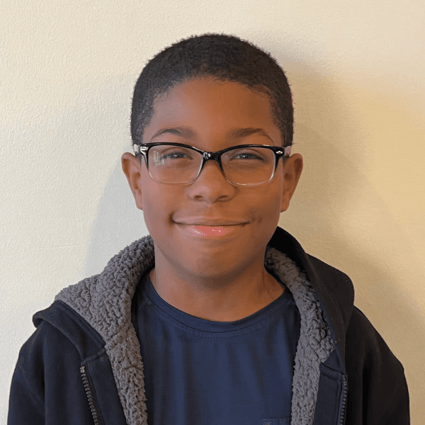 A headshot of a smiling client against an office wall.