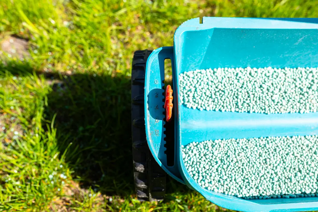 top down view of pellet lawn fertilizer spreader on top of lush green lawn