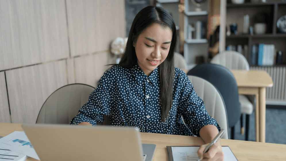Business woman busy writing and working in her laptop