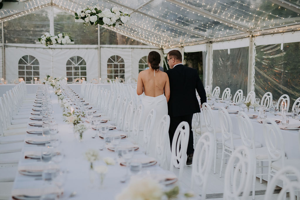 Bride & groom walking through their reception set up before guest arrival