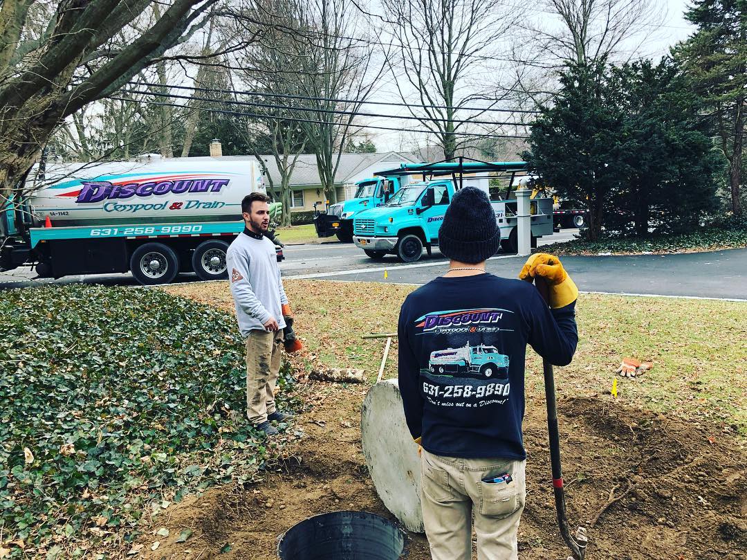 Cesspool pumping truck and crew servicing a Long Island street