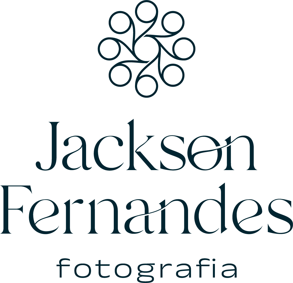 Logotipo principal da marca Jackson Fernandes Fotografia em versão vertical, apresentando o ícone circular com traços curvos no topo, seguido pelo nome do fotógrafo e a palavra 'fotografia' abaixo em tom azul-escuro sobre fundo branco.
