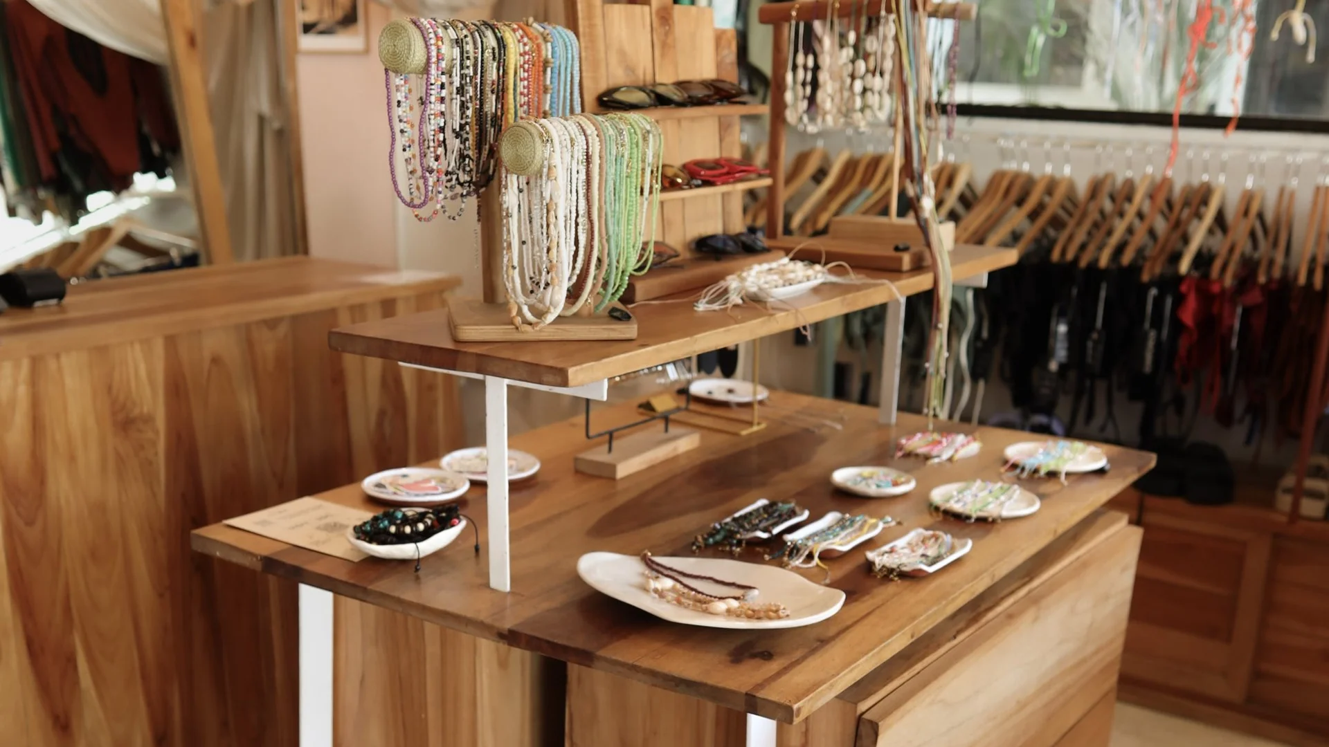 Boutique interior with handmade jewelry and clothing displayed on wooden tables