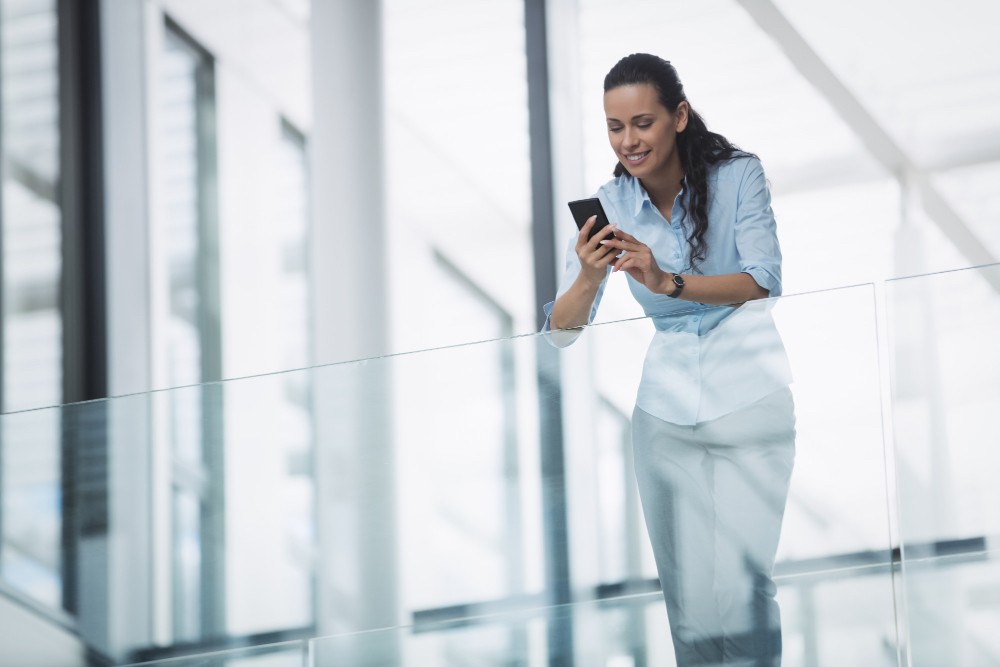 Woman smiling while working on a tablet, representing ongoing software access and support through a monthly plan.