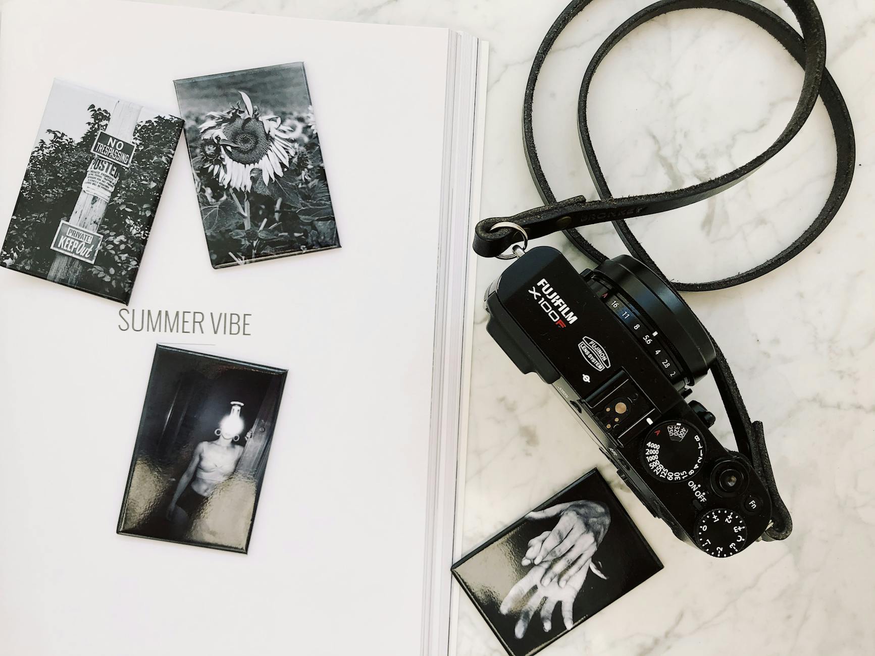 A hand sorting through various printed art history cards and photographs on a wooden tabletop.