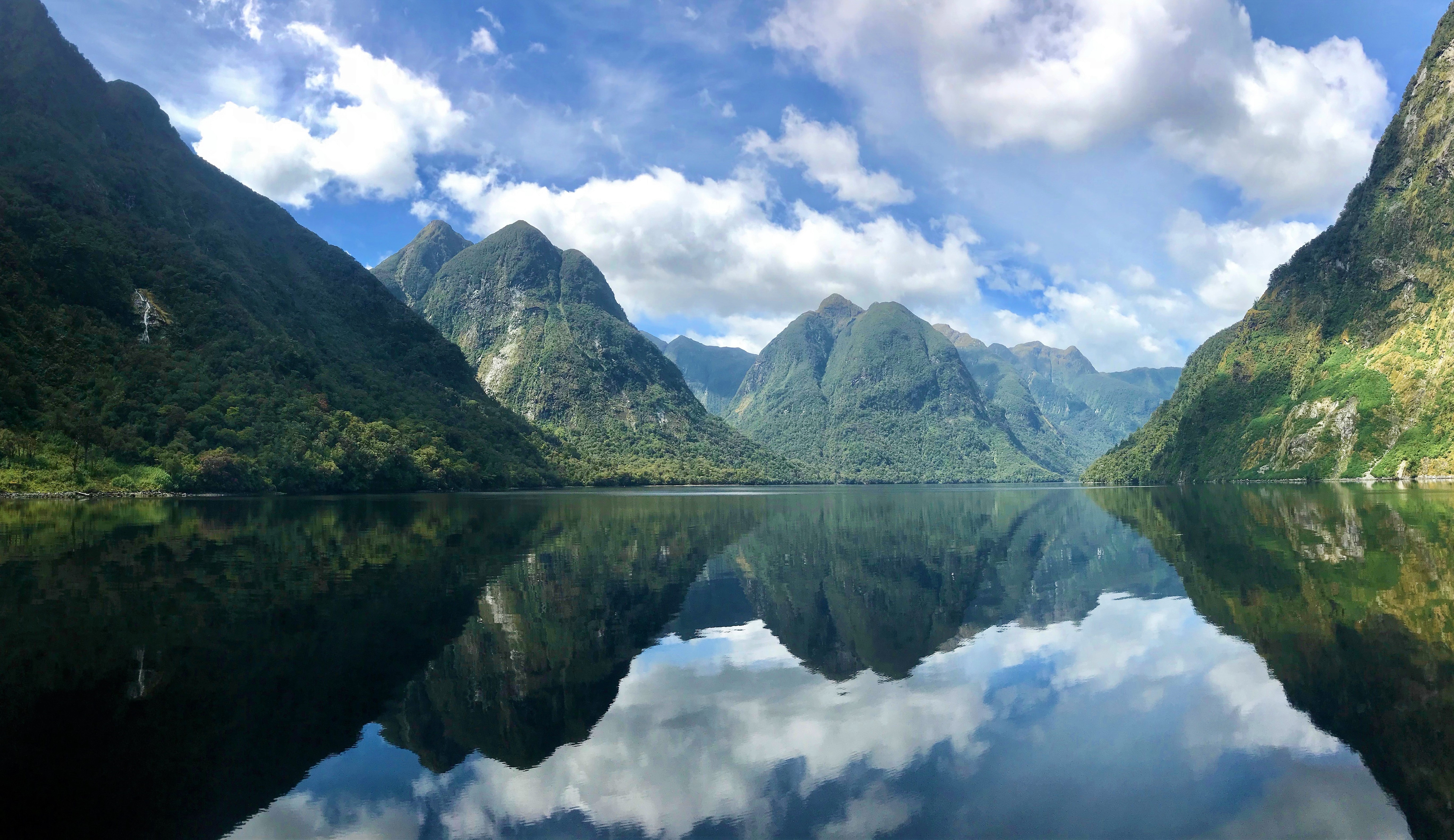 The reflection of the fjords and sky in the perfectly still water of Doubtful Sound, New Zealand