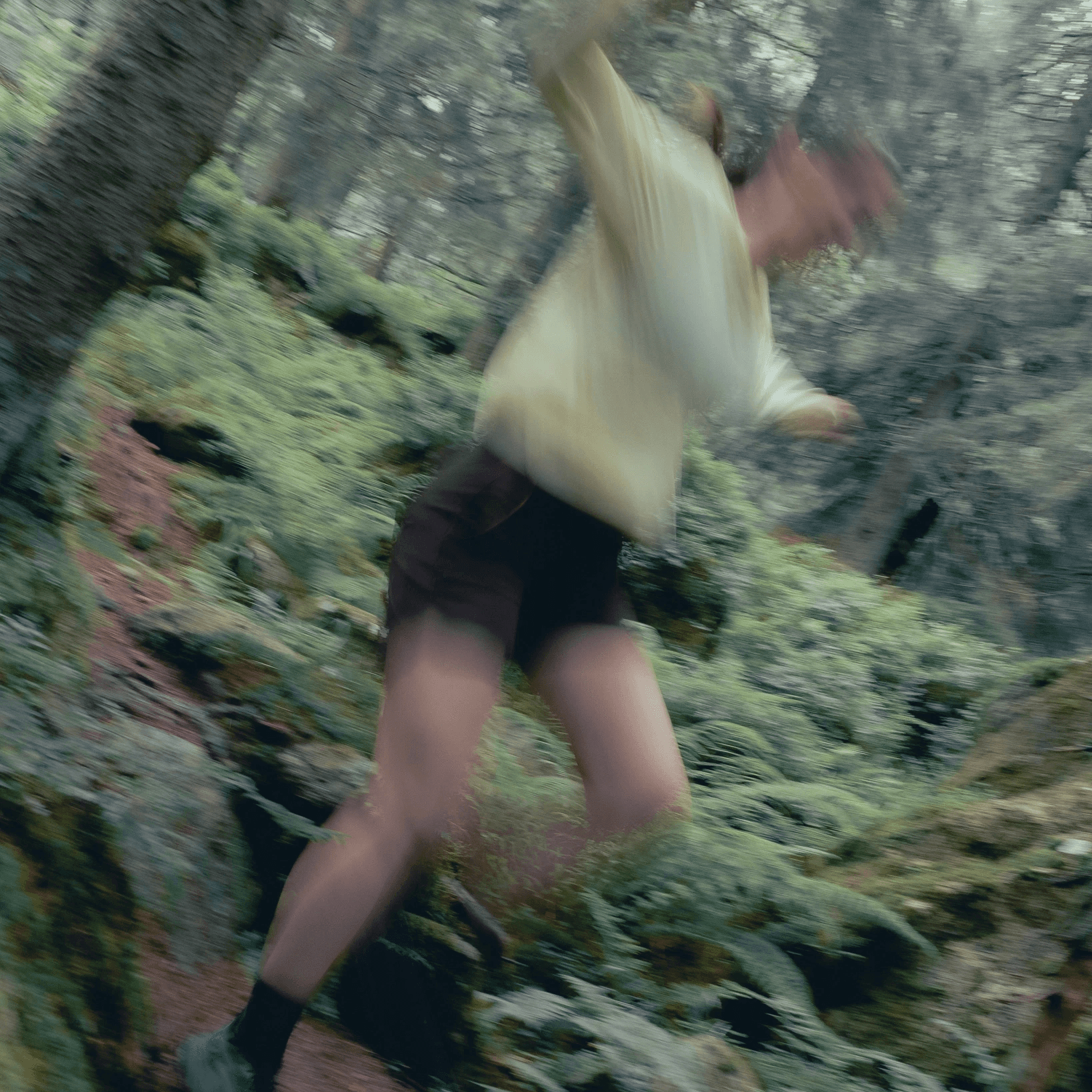 blurry picture of a woman running in the forest.