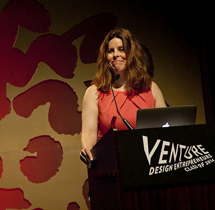 portrait of a woman with an orange dress giving a speech