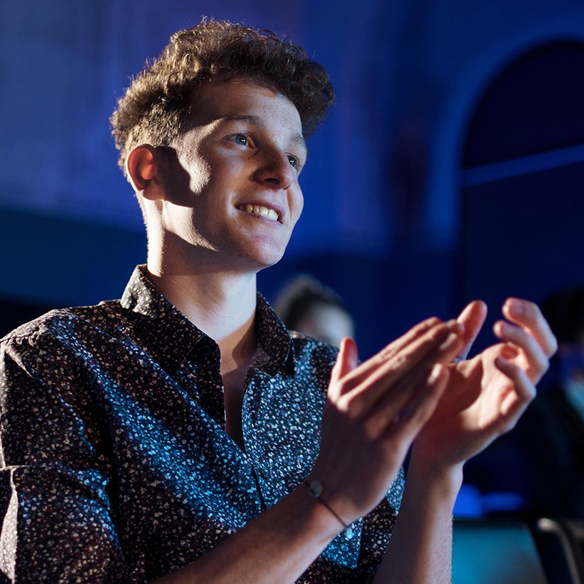 Happy attendee clapping in hall