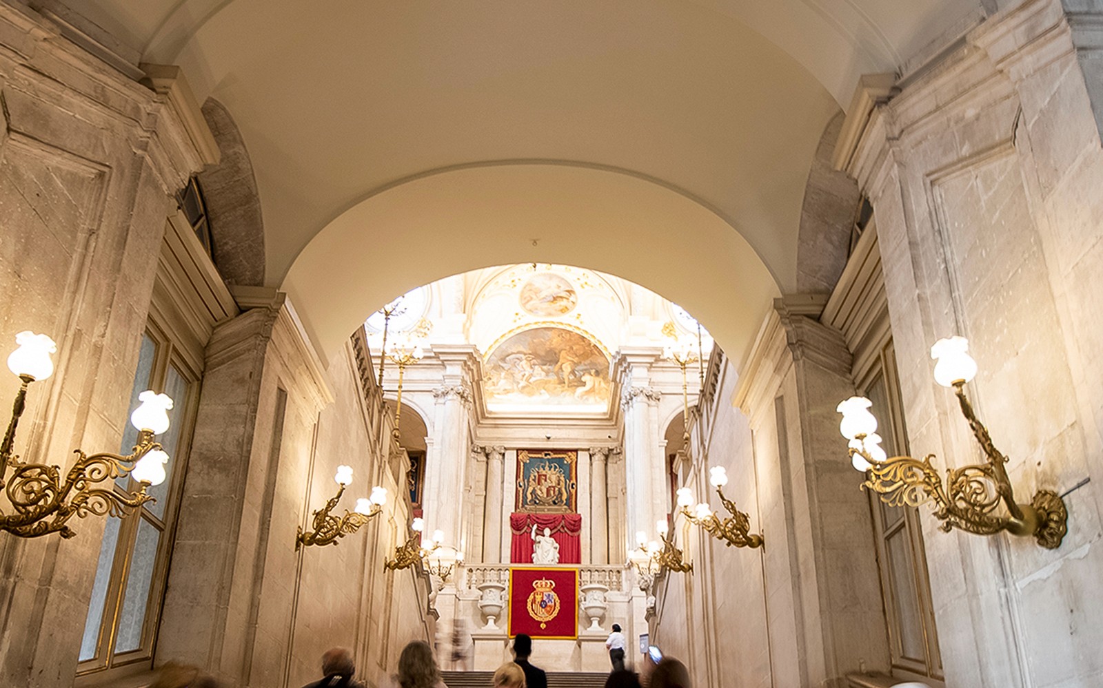 马德里皇宫内的大阶梯，配有精美吊灯和皇家徽章。