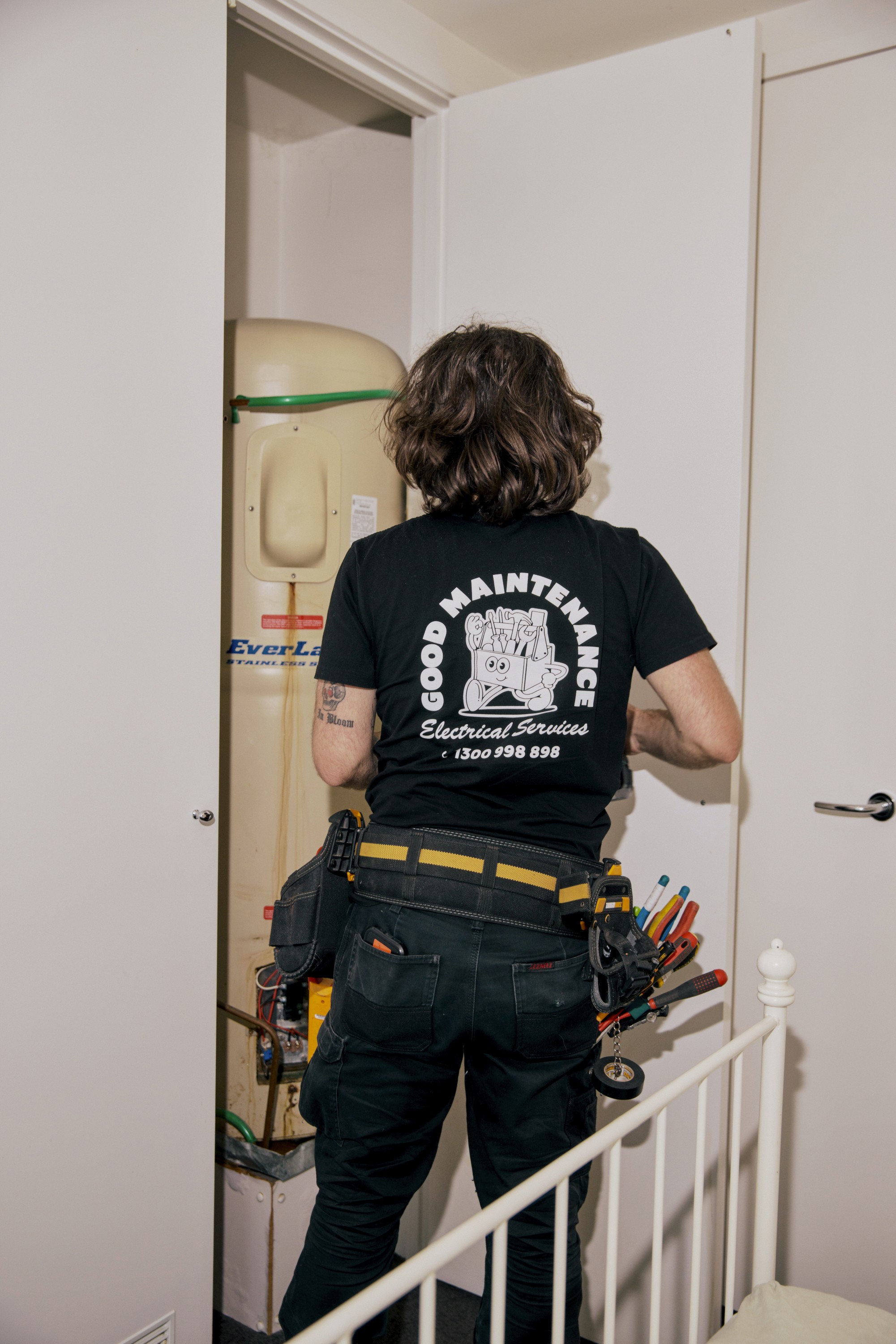 A Good Maintenance team member wearing a company shirt with graphics.