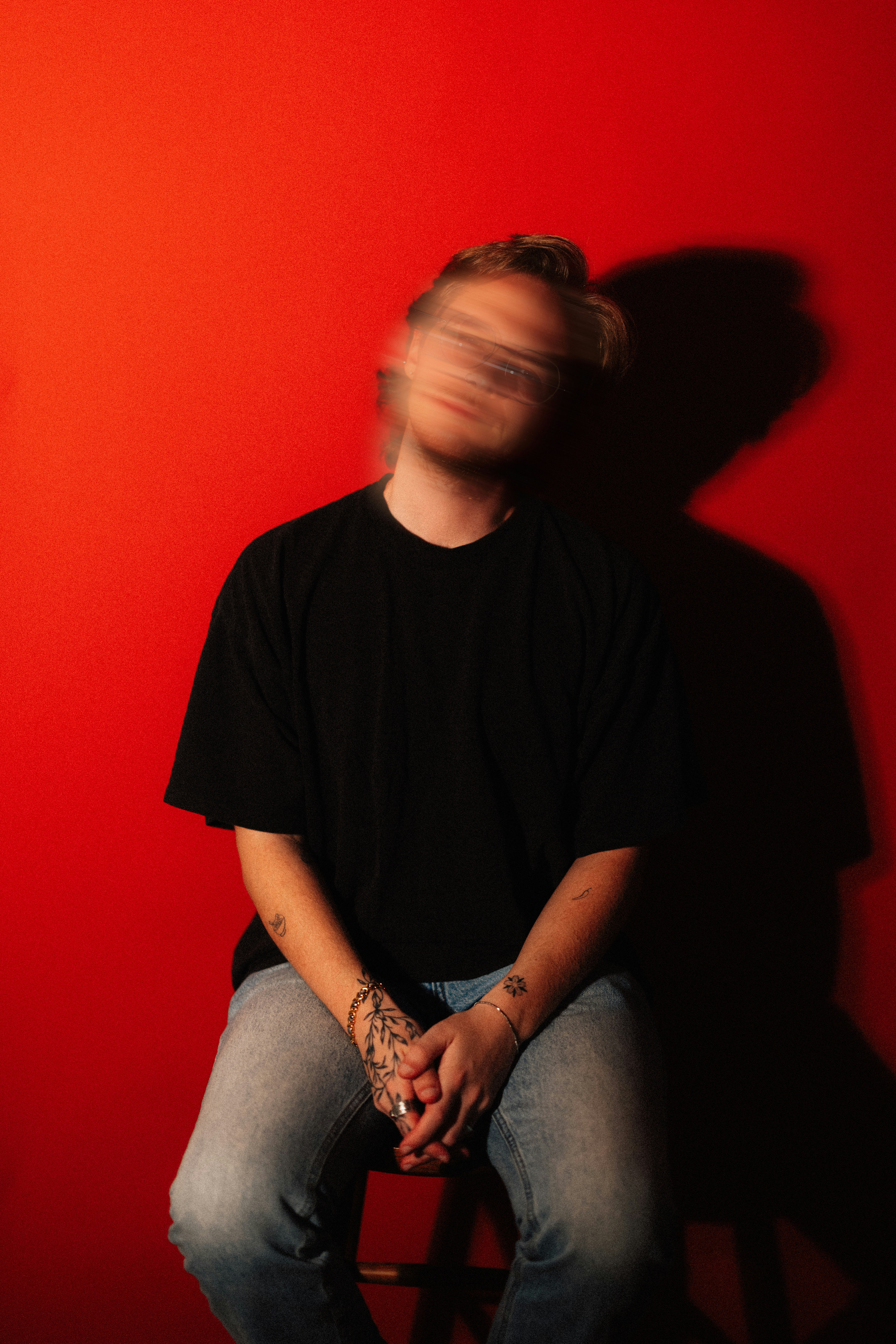 Person with blurred face against red wall