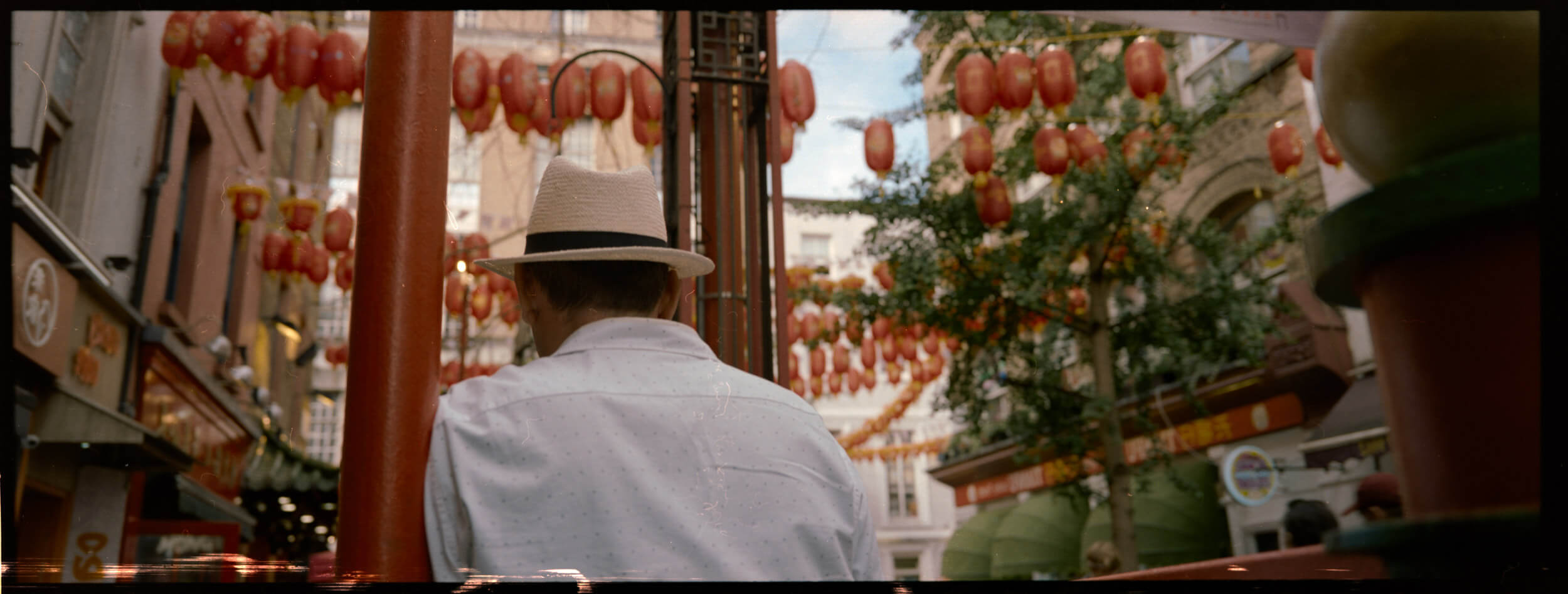 A man standing amongst chinese new year lanterns in London shot on film on the Hasselblad XPan 