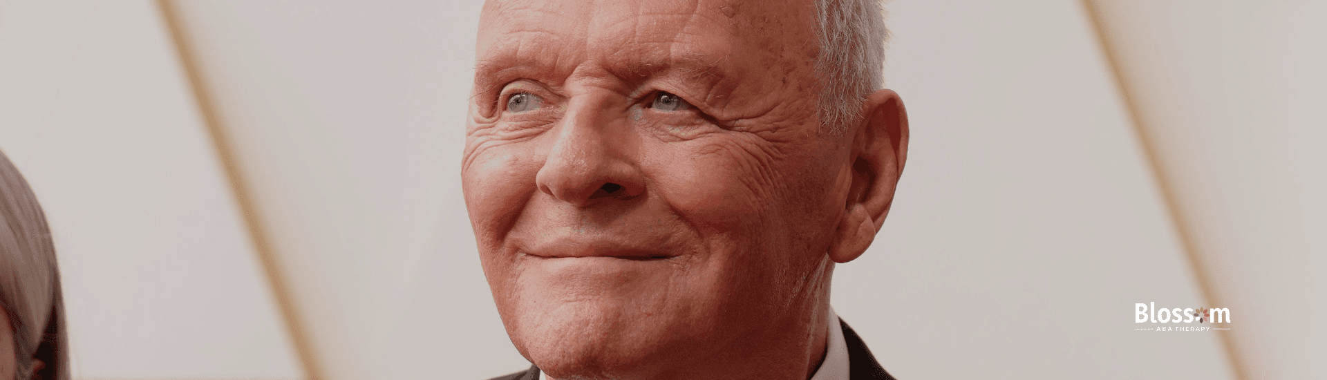 Anthony Hopkins smiles while wearing a black tuxedo at an autism advocacy event in Georgia.