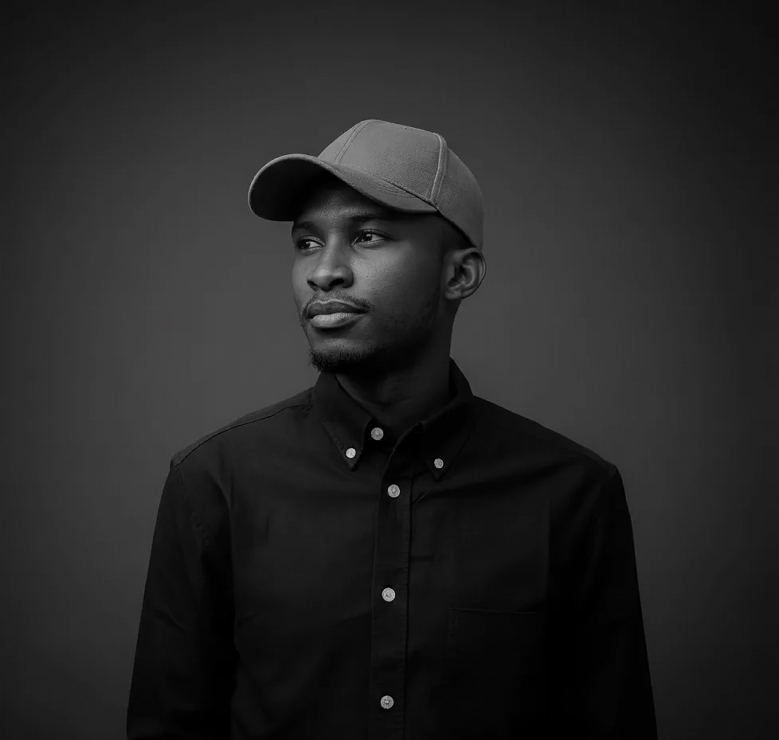 Portrait of man looking to the left and smiling with a dark background