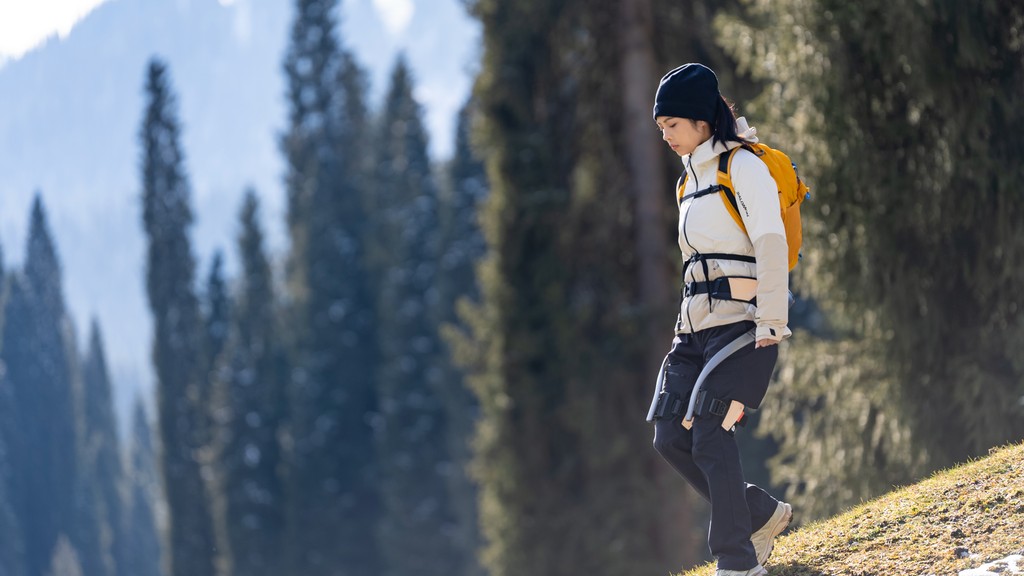 Utilisatrice équipée de l’exosquelette Hypershell lors d’une randonnée, bénéficiant d’un soutien actif pour réduire la fatigue musculaire et prolonger la marche en plein air.