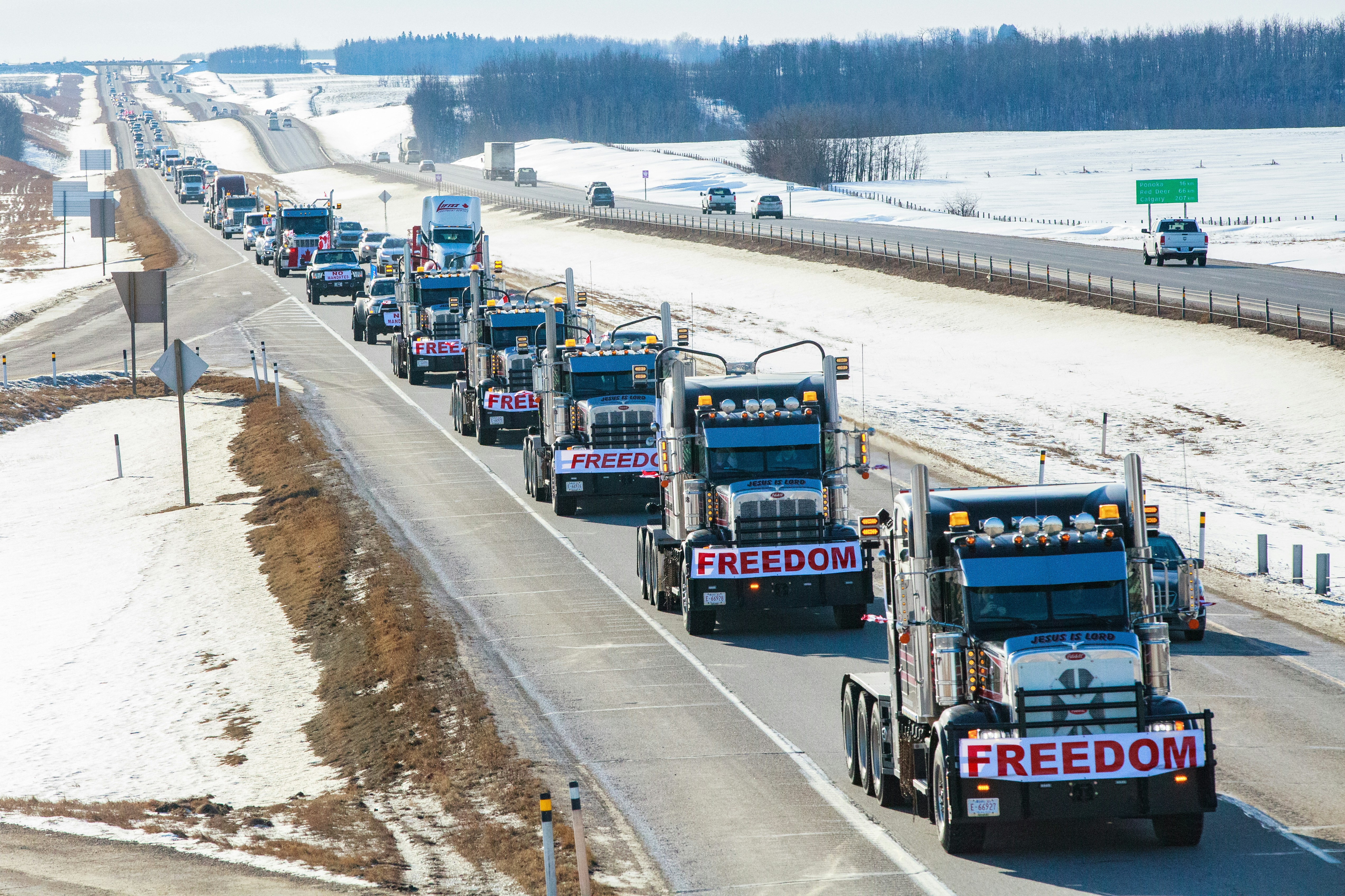 a long line of trucks driving down a highway