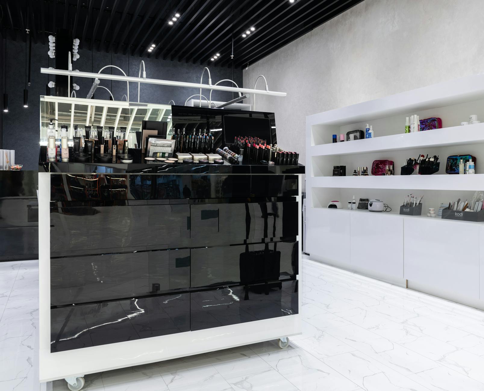 Wide-angle view of a sleek, contemporary cosmetics display in a stylish store interior.