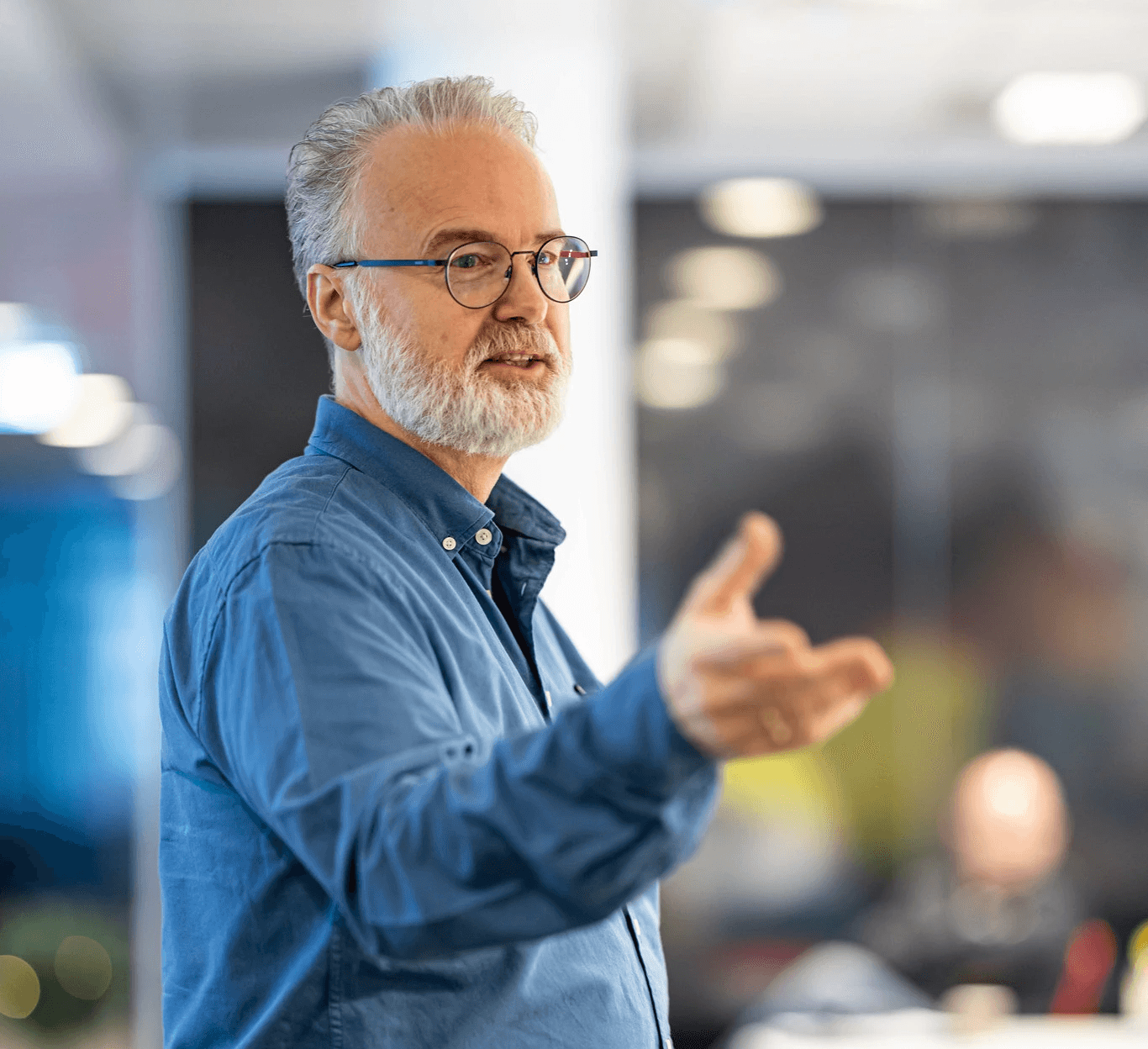 A person wearing a virtual reality headset stands in front of multiple screens, engaged in a digital experience.