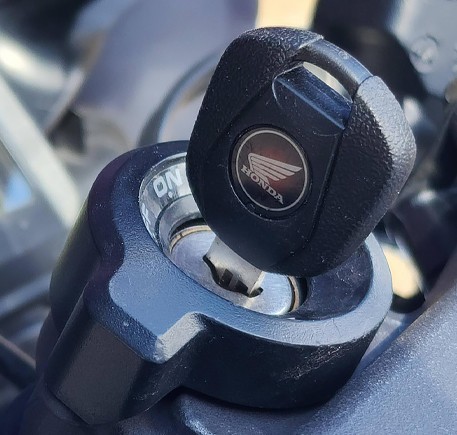 Motorcycle key inserted in Honda ignition after service by CarKeyAction locksmith.