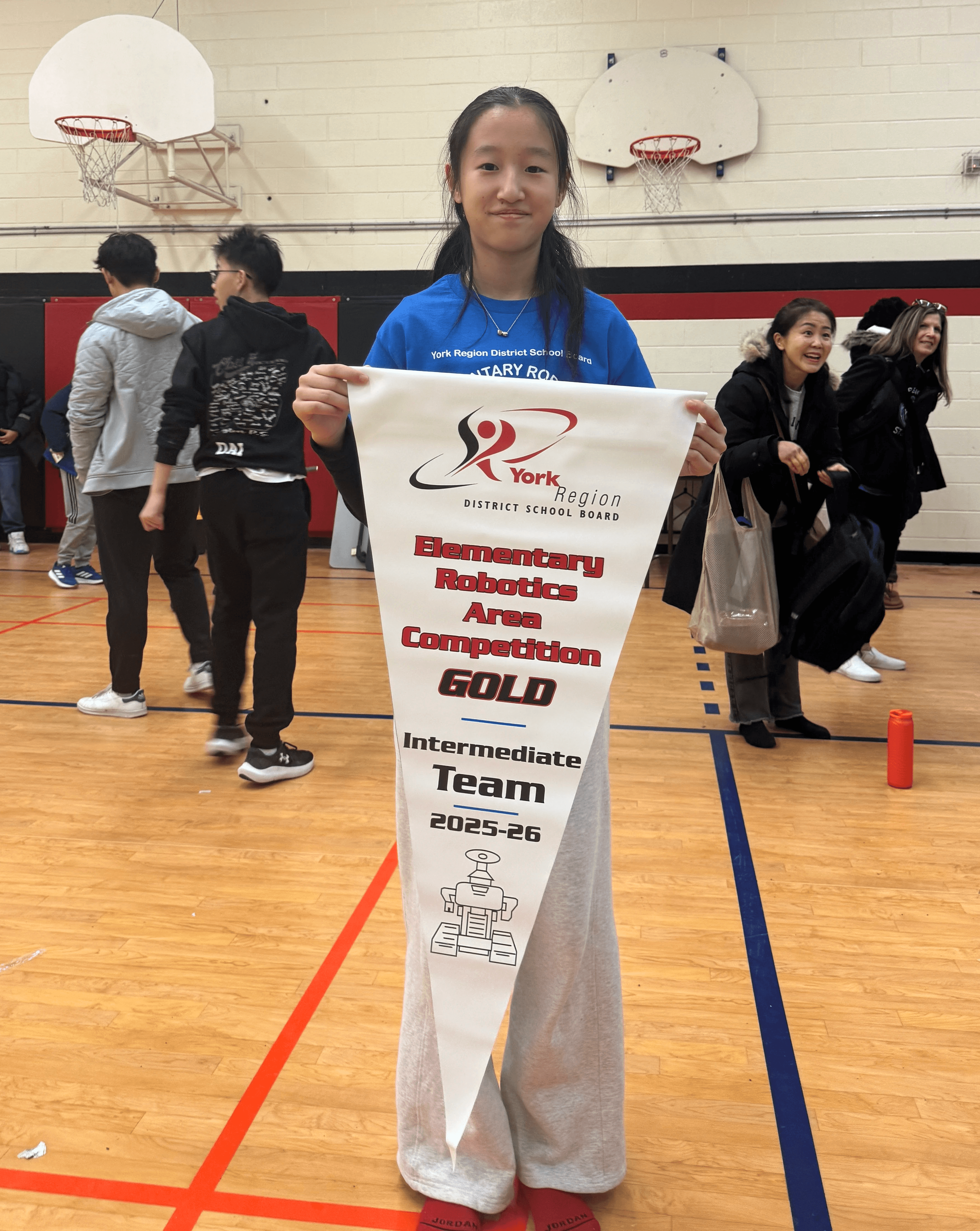 Renee Zhang holds the championship banner after Rick Hansen Public School’s 1st Place finish at the York Region Skills Challenge Intermediate LEGO Robotics Challenge Area Competition.