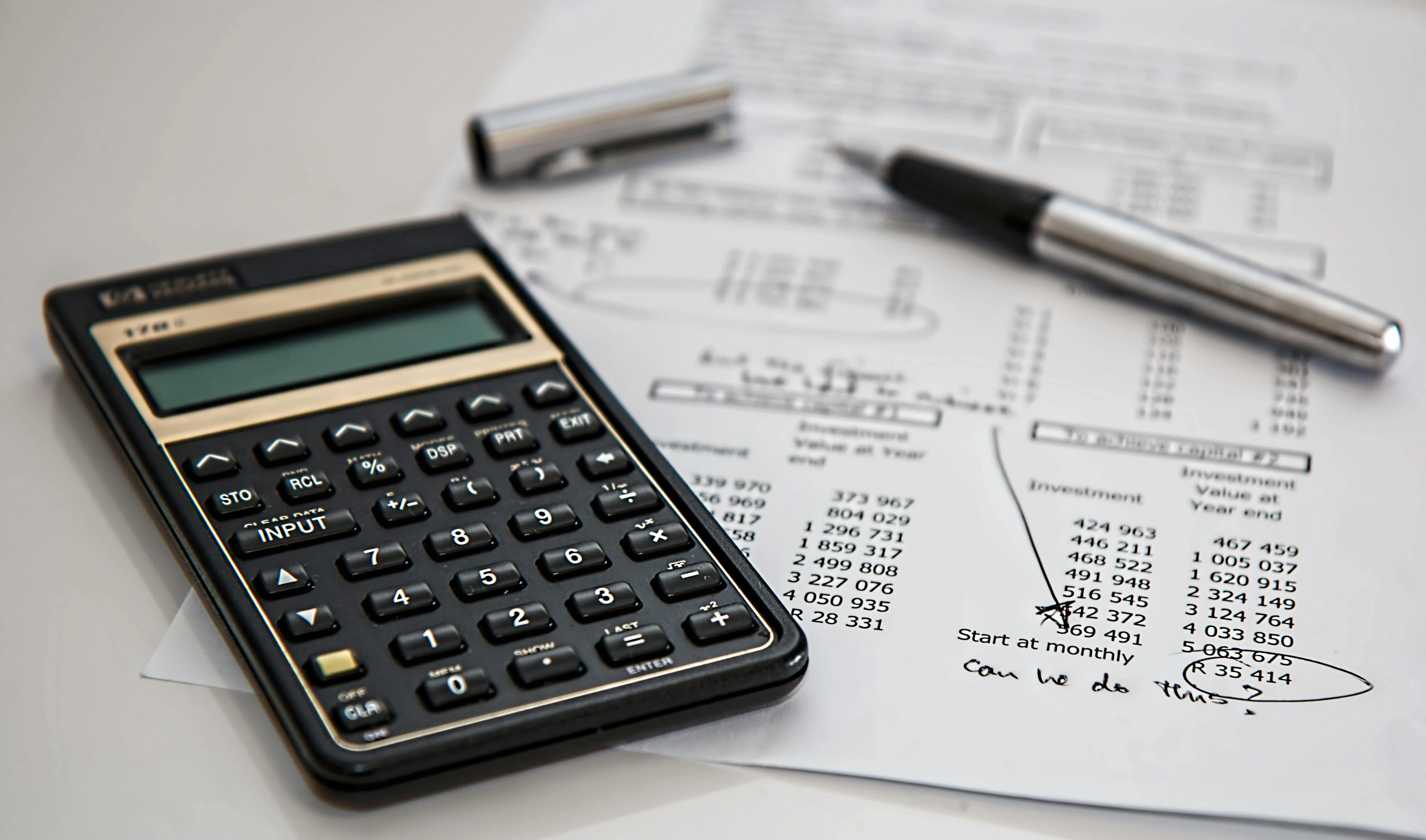 A calculator and sheet with a pen