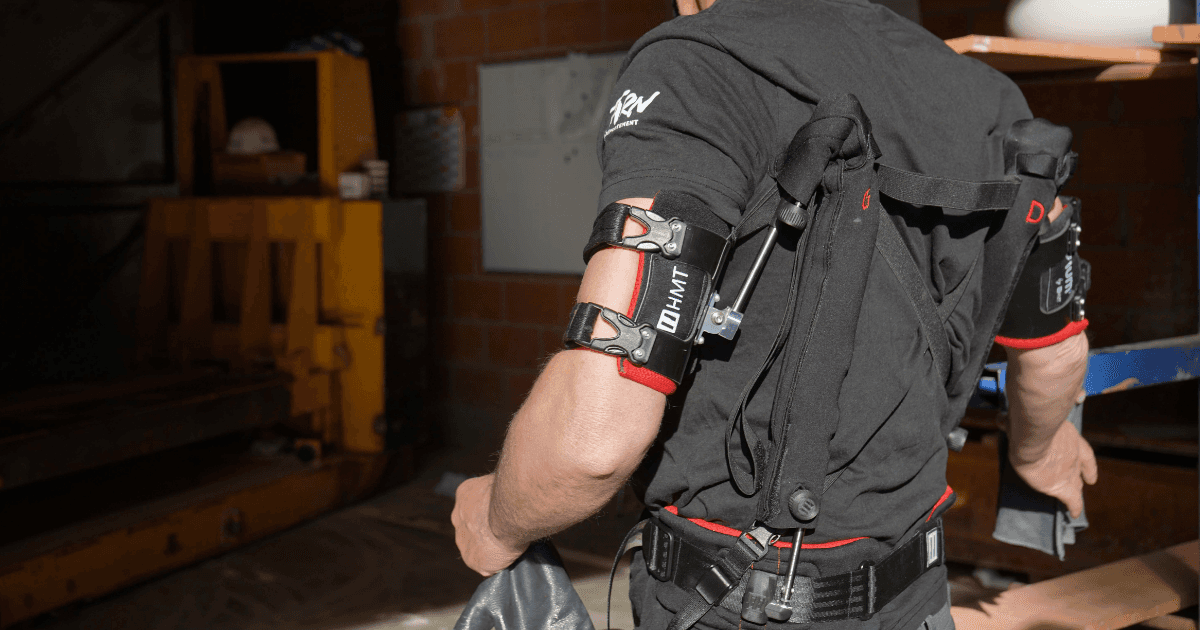 Travailleur équipé d'un exosquelette de bras et épaule dans un environnement industriel, optimisant la productivité et la sécurité dans les tâches de levage."