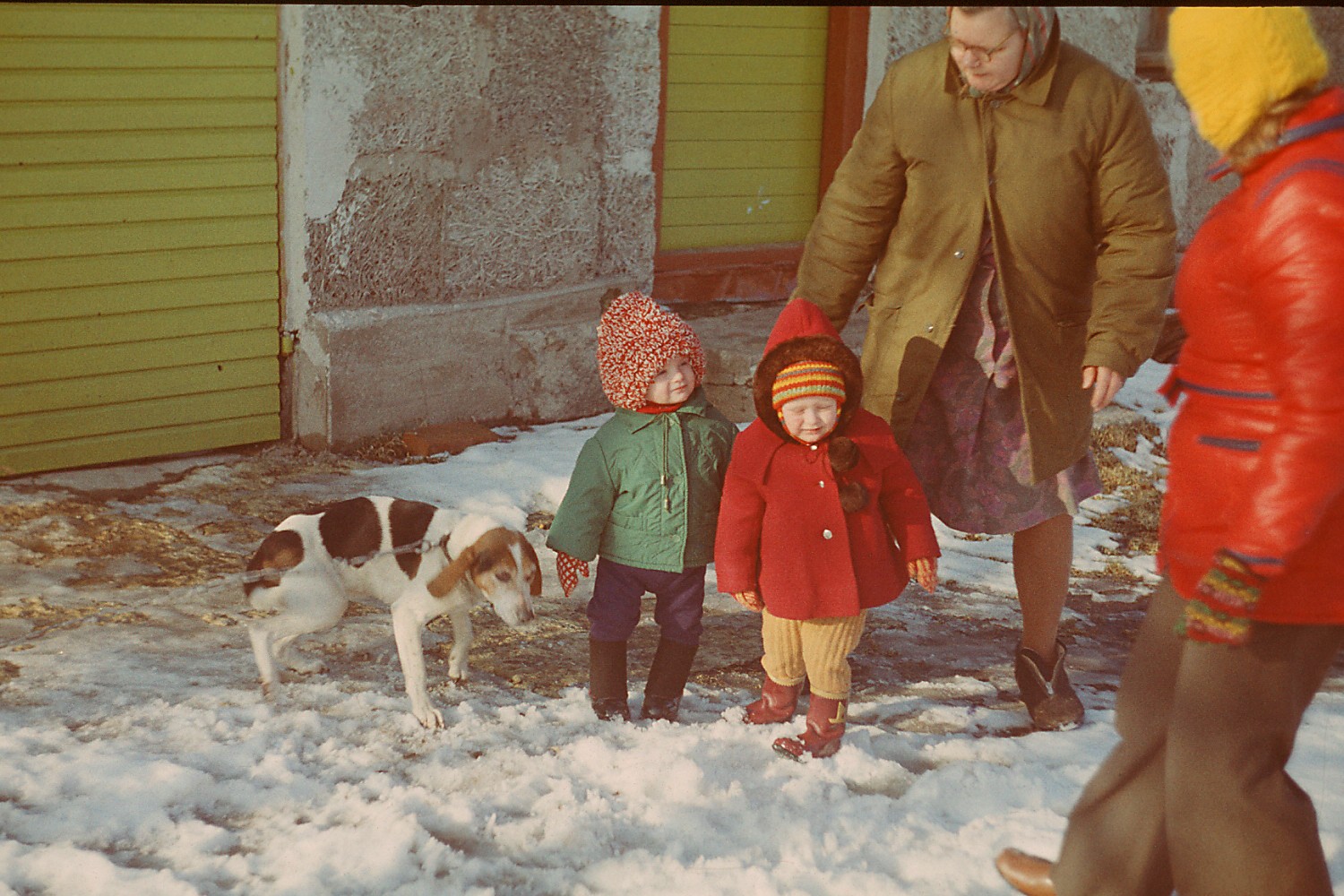 Kaks last, kaks täiskasvanut ja koer talvel maja ees