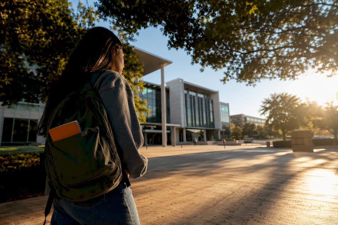 Estudiante caminando por el campus universitario