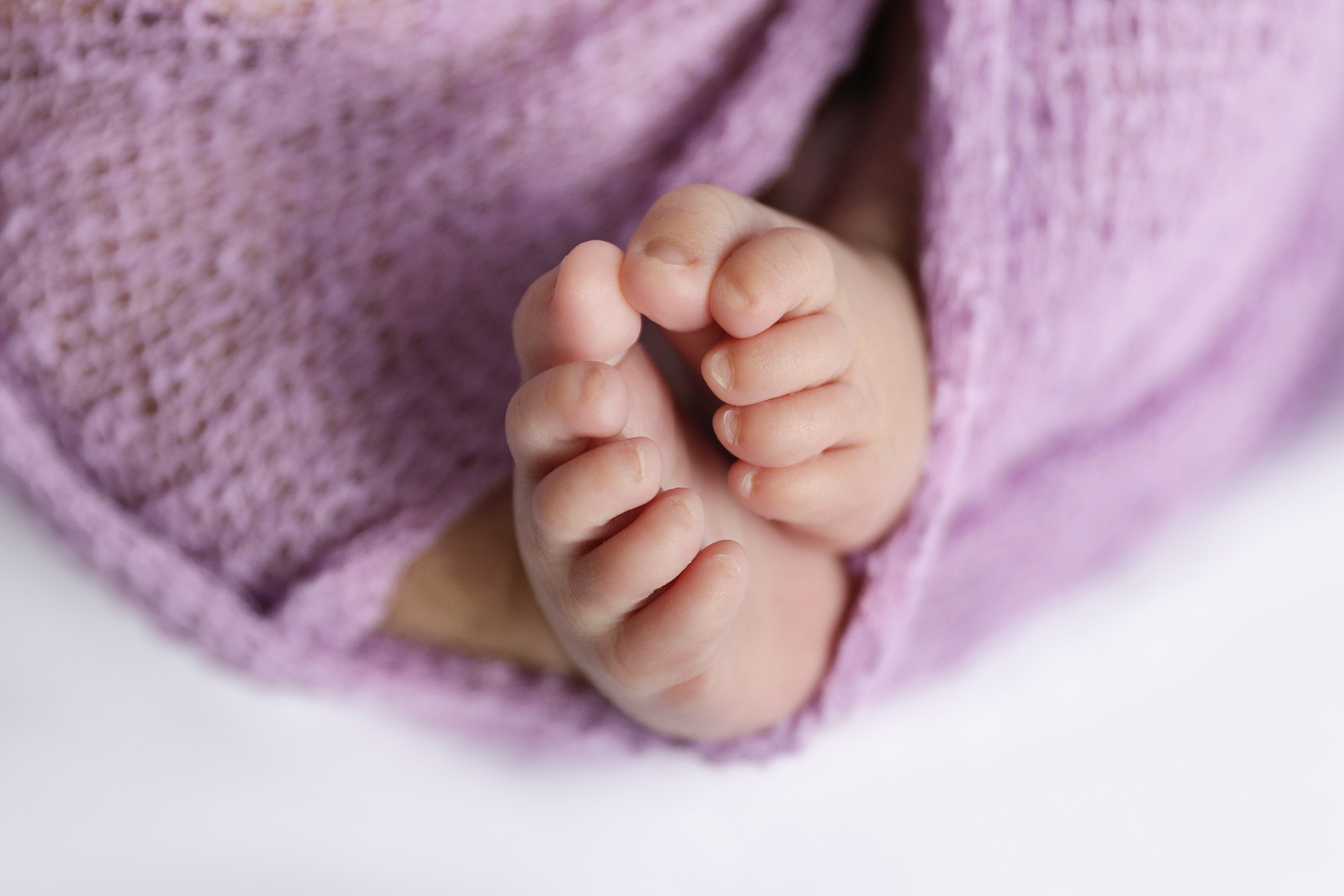 Close-up photo of a newborn’s feet swaddled